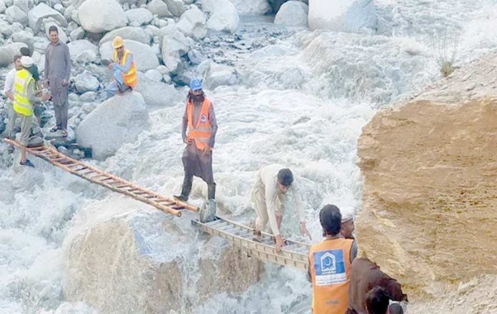 الخدمت کے رضا کار چترال میں گلیشیئر پگلنے کے نتیجے میں آنے والے سیلاب میں پھنسے افراد کو محفوظ مقام پر منتقل کررہے ہیں