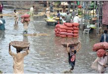لاہور: بارش کے بعد سبزی فروش اپنا سامان اُٹھائے جا رہے ہیں